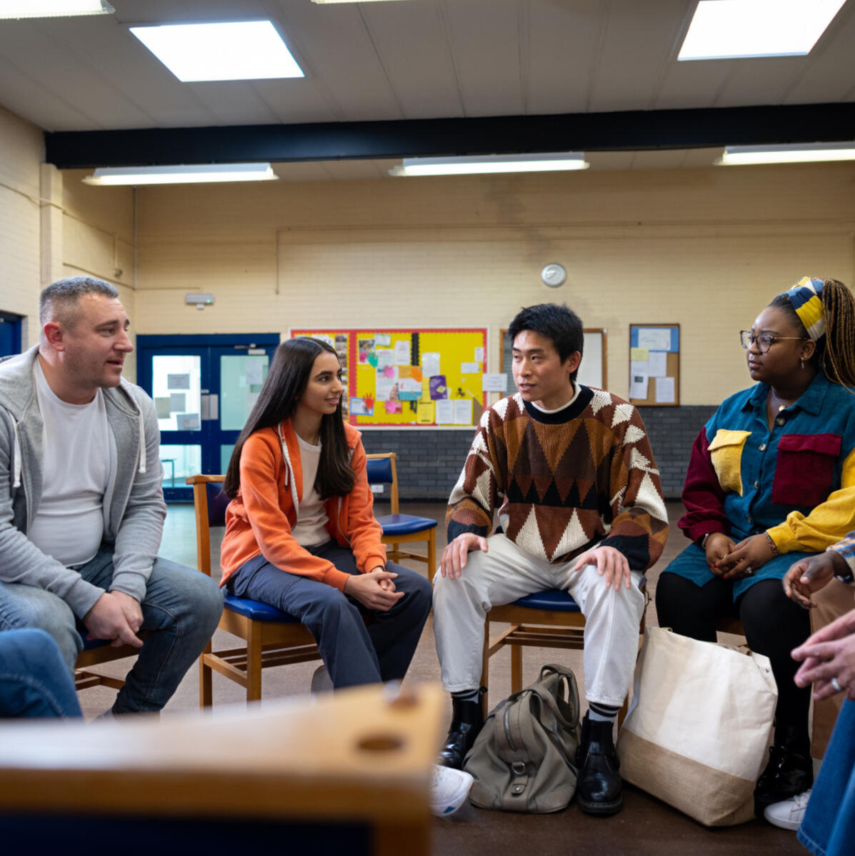 Community Employment Services Ontario - 4 individuals sit on chairs in a semi circle in discussion.